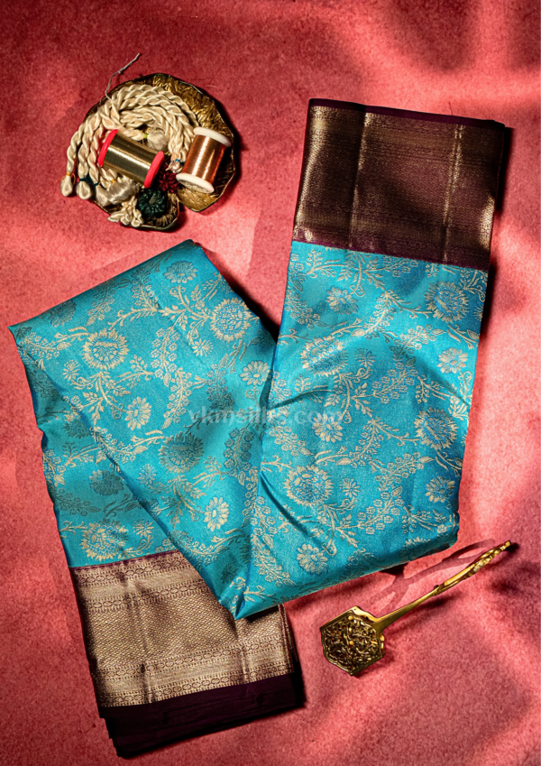 9 - 2026-09-03T174209.909 Rich Mayil blue body with intricate zari floral weaving, paired with a classic deep maroon antique gold border.