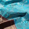 9 - 2026-09-03T174712.555 Rich Mayil blue body with intricate zari floral weaving, paired with a classic deep maroon antique gold border.